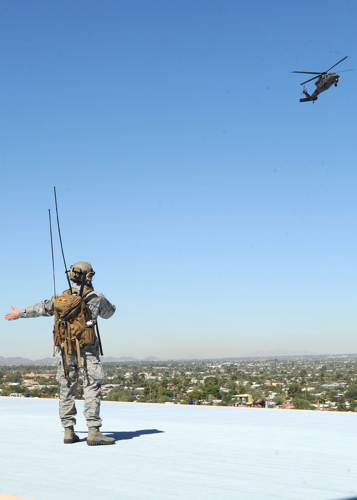 U.S. Air Force Senior Master Sgt. Nathan Zinn, 48th Rescue Squadron superintendent, directs an HH-60 Pave Hawk where to land at University of Arizona Medical Center Oct. 11. Angel Thunder serves as the only venue within Department of Defense and the U.S. Government where personnel recovery operations are exercised across the breadth of military operations. (U.S. Air Force photo by Senior Airman Brittany Dowdle)