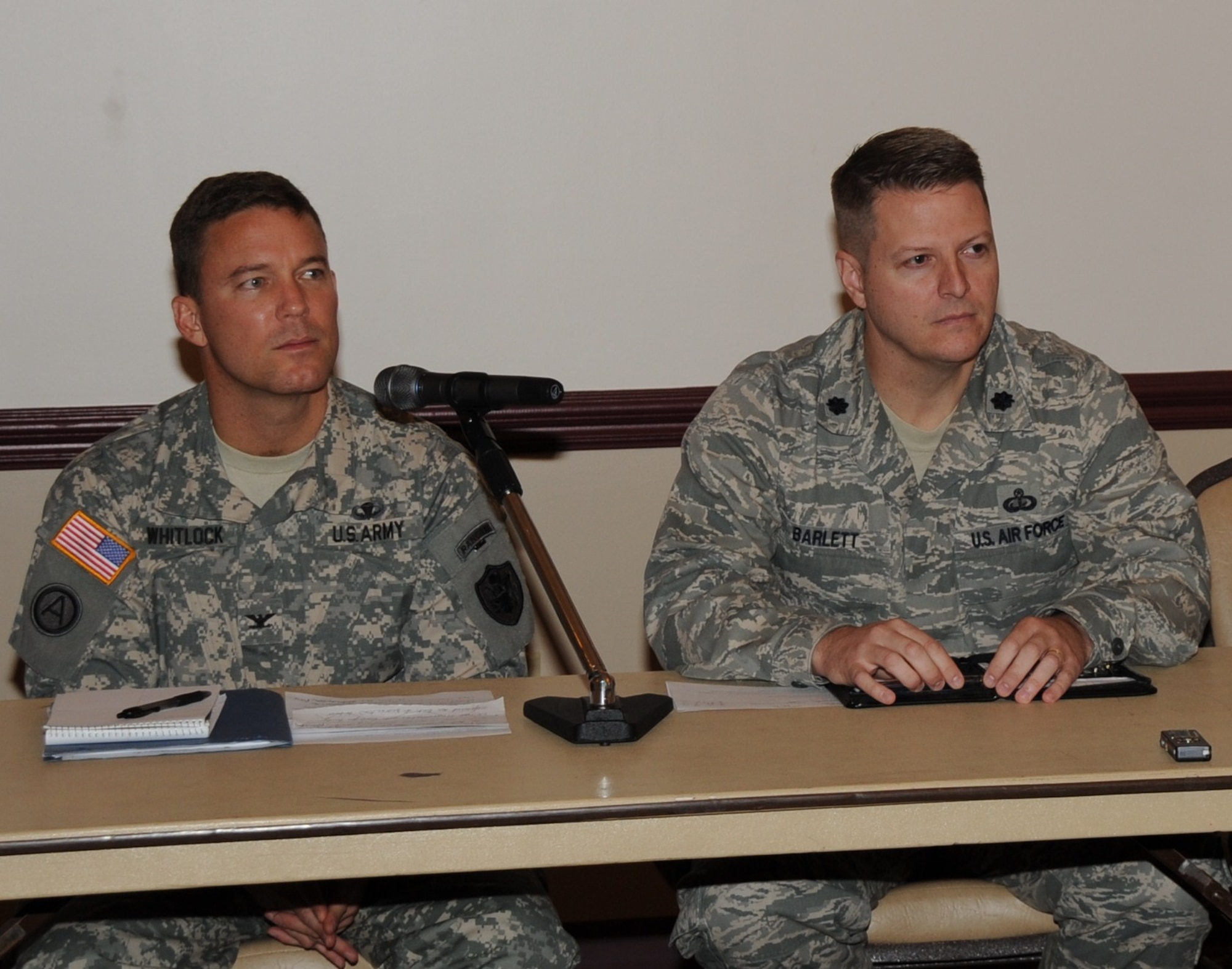 Col. Joseph Whitlock, joint base deputy commander, left, and Lt. Col. John Barlett, 87th Mission Support Group deputy commander, listen to questions from mock reporters during a simulated press conference about a fictitious biological agent attack here Oct. 7. Also in attendance but not pictured were Capt. Shannon Oneal, 87th Security Forces Squadron operations officer and Lt. Col. Lynn Berry, 87th Aerospace Medical Squadron. The purpose of the media training exercise was to prepare base leadership in responding to questions from members of the press during crisis and emergency situations. (U.S. Air Force photo by Pascual Flores/Released)