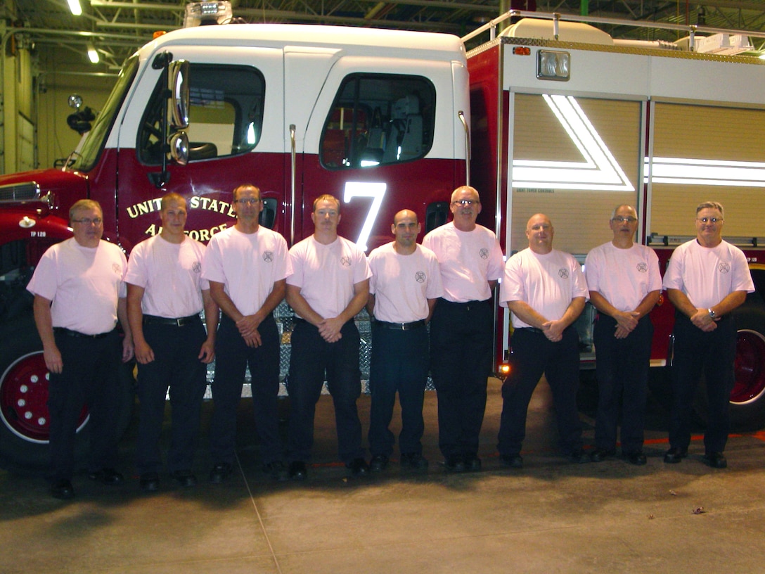 SIOUX FALLS, S.D. - Members of the A shift of the Crash, Fire, Rescue station at Joe Foss Field have their photo taken in their pink shirts they purchased and wore in honor of Breast Cancer Awareness month here October 11, 2011.  Firefighters at the station raised funds to support the foundation during the month of October which is also Fire Prevention month. (National Guard photo by Charles Kludt, CIV)(RELEASED)