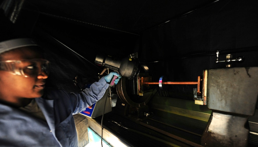 U.S. Air Force Staff Sgt. Tanita Johnson, 23rd Equipment Maintenance Squadron non-destruction inspections floor lead, uses a magnetic particle to inspect parts of an aircraft for defects at Moody Air Force Base, Ga., Oct. 11, 2011. After the aircraft parts are coated in a special liquid, a black light is used to look for liquid which may have seeped into the defects, creating a glowing effect within the flawed area.  The glowing effect helps with detection. (U.S. Air Force photo by Staff Sgt. Stephanie Mancha/Released)