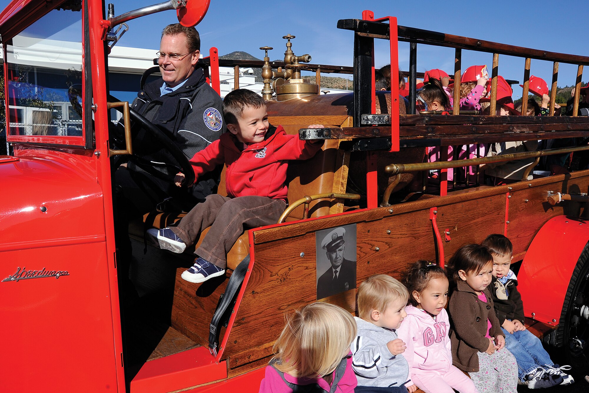 Children at the Air Force Academy's Child Development Center check out the Academy Fire Department's REO Speedwagon Oct. 12, 2011, as part of the Academy's Fire Prevention Week activities. The vintage truck is a gift from the family of Fire Chief Golden Simmons, who is credited with organizing the Academy's first fire department. (U.S. Air Force photo/Mike Kaplan)