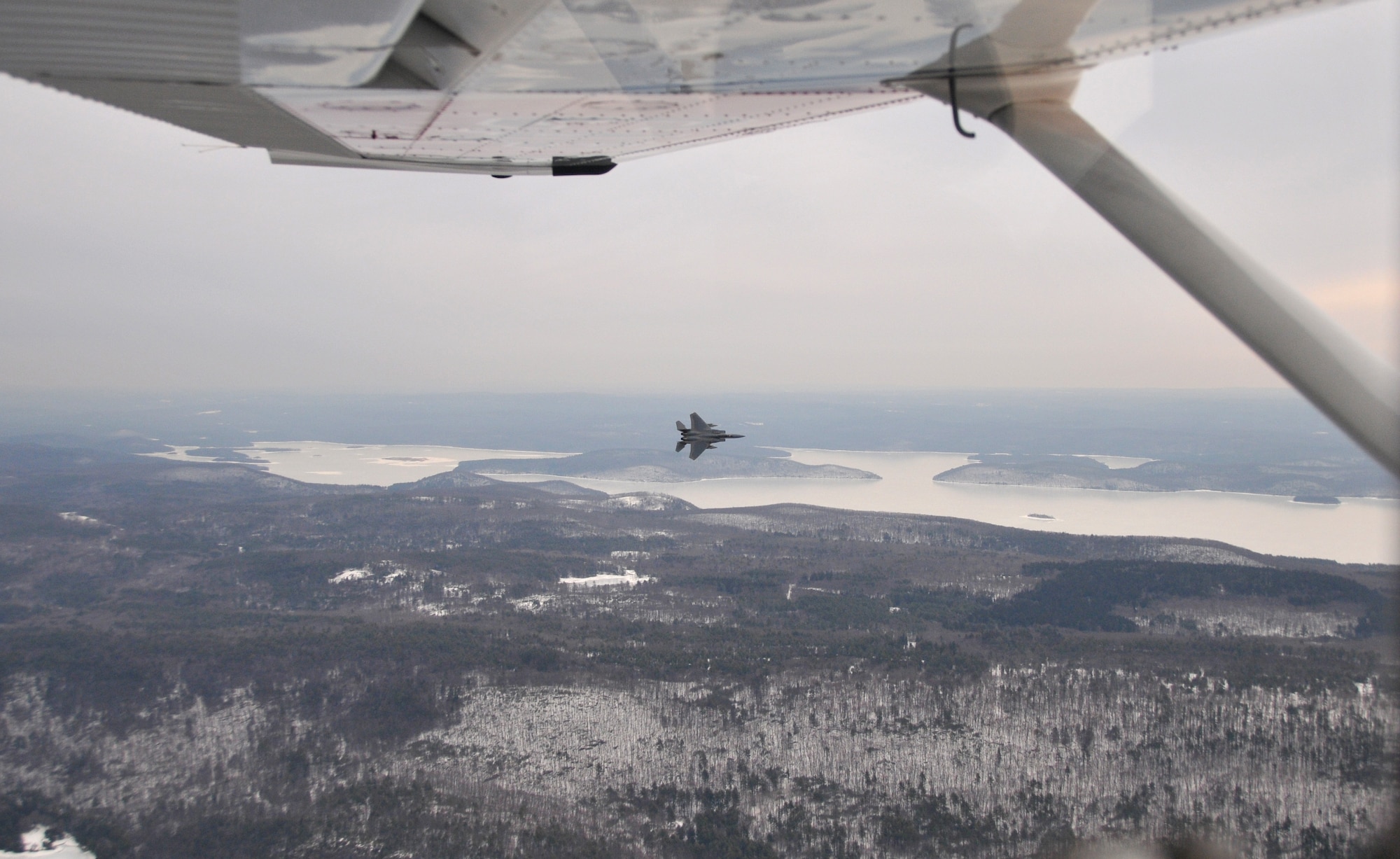 An F-15 from the 104th Fighter Wing of the Massachusetts Air National Guard is seen outside the window of a Civil Air Patrol aircraft during an intercept training mission over the White Mountains in New Hampshire. Civil Air Patrol helps Aerospace Control Alert units train for scrambles and intercepts by providing a track of interest. (Courtesy photo)