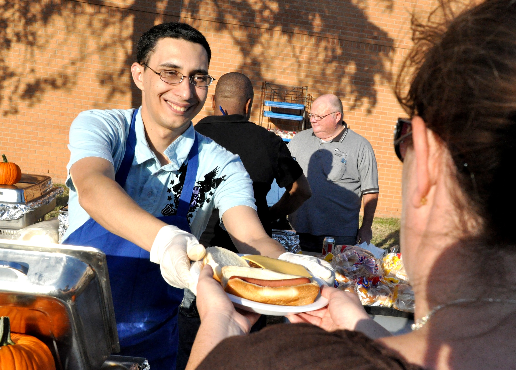 Senior Airman Travis McCallum, with the 71st Logistics Readiness Squadron, serves up a hot dog and a hamburger during the Fall Fest celebration Oct. 6 at Vance Air Force Base, Okla. (U.S. Air Force photo/ Airman 1st Class Frank John Casciotta)