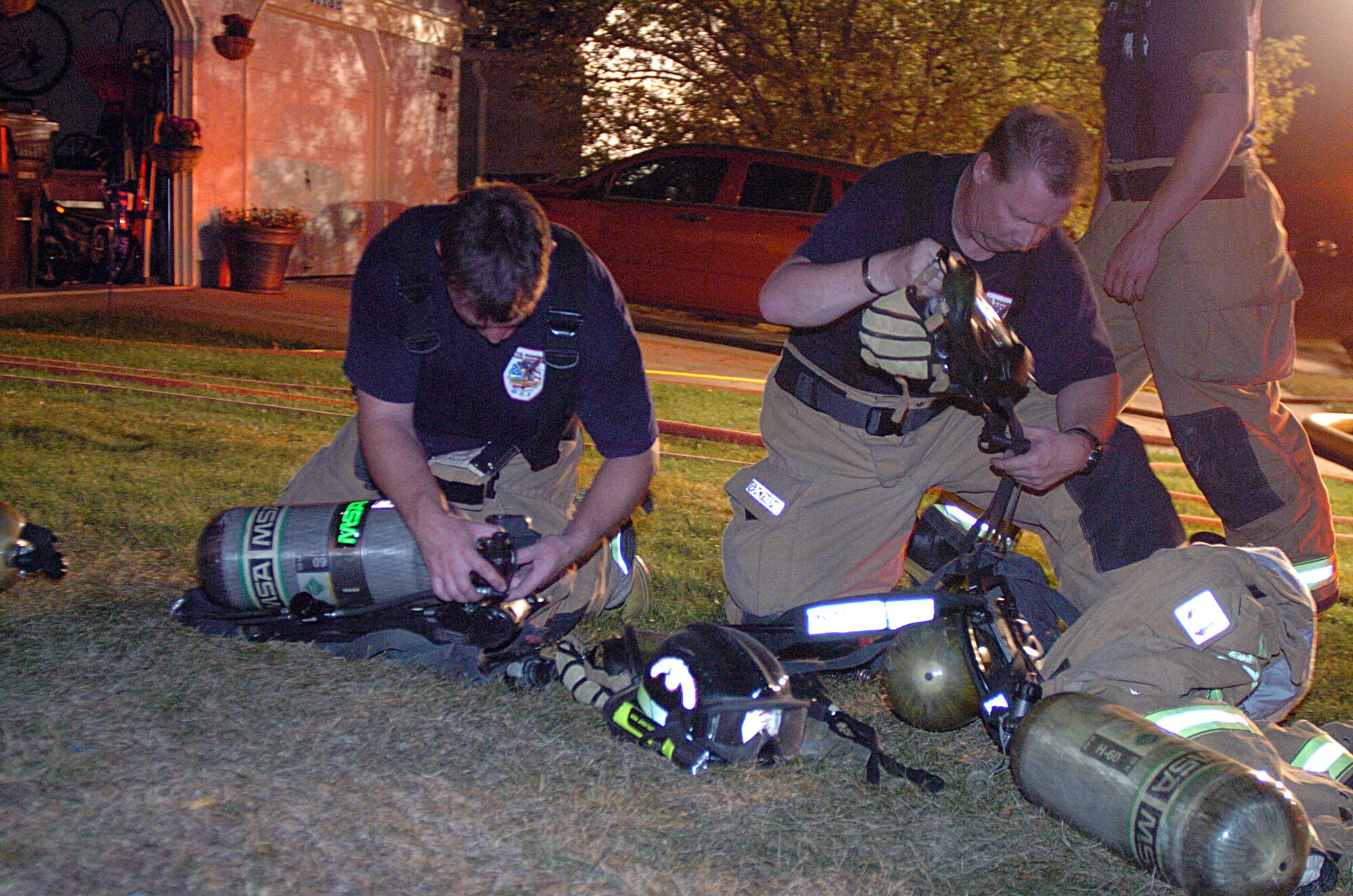 Firefighters with the 90th Civil Engineer Squadron, ready their equipment as they prepare to enter a structure at the scene of a house fire Oct. 2. (U.S. Air Force photo by R.J. Oriez)