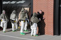 Tech. Sgt. Sarah Drinkard, 90th Medical Operations Squadron, assists wounded Master Sgt. Eugene Renner, 90th Missile Security Forces Squadron, in sitting against the wall during a base exercise here Sept. 21. (U.S. Air Force photo by Blaze Lipowski)