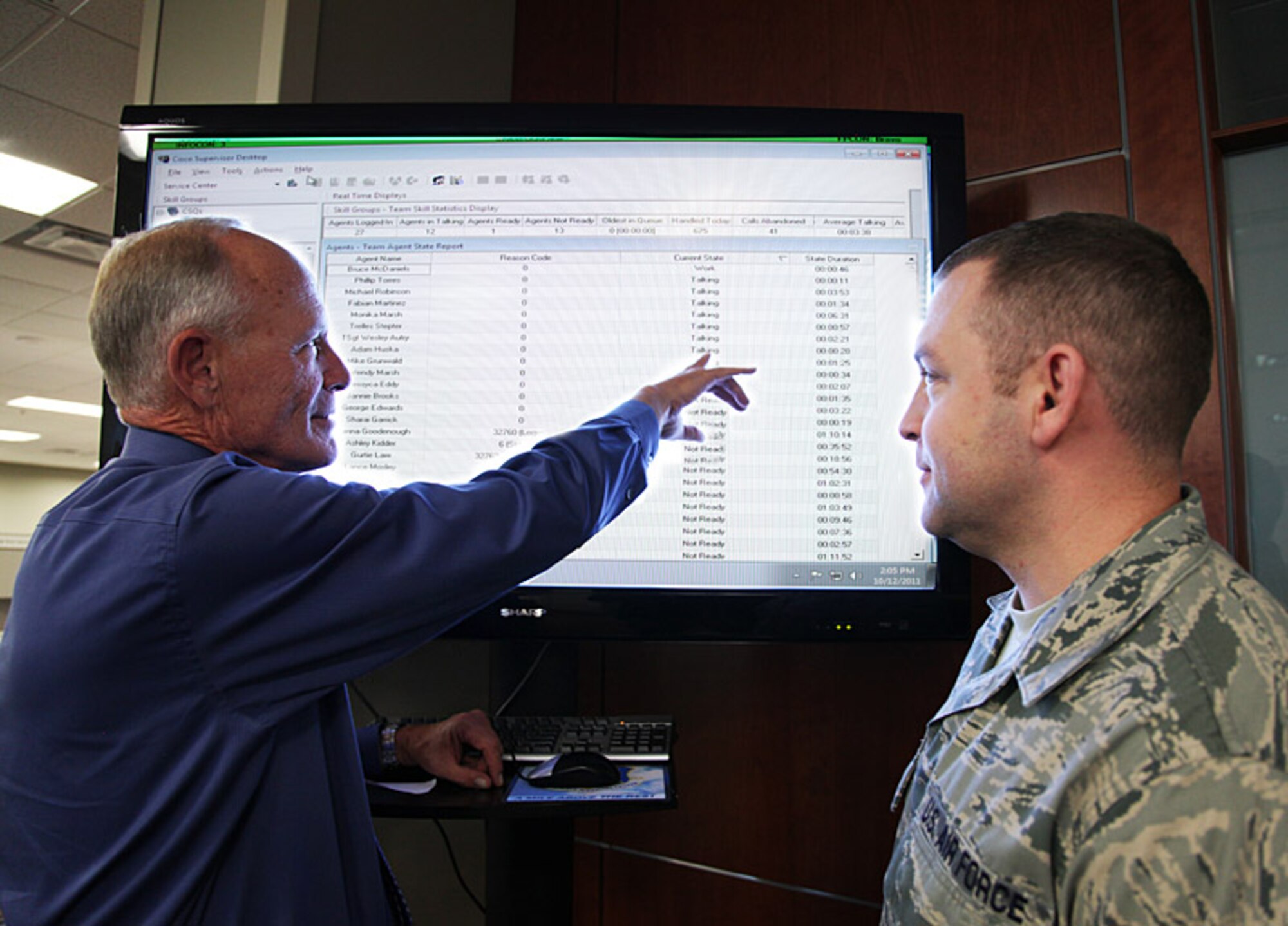Dan Brandenburger, Air Reserve Personnel Center chief of contact center operations, and Master Sgt. Joe Smith, Air Force Personnel Center sustainment superintendent, discuss incoming phone volumes during the ARPC/AFPC Continuation of Operations Exercise Oct. 12, 2011, at Buckley Air Force Base, Colo. (U.S. Air Force photo/Quinn Jacobson)