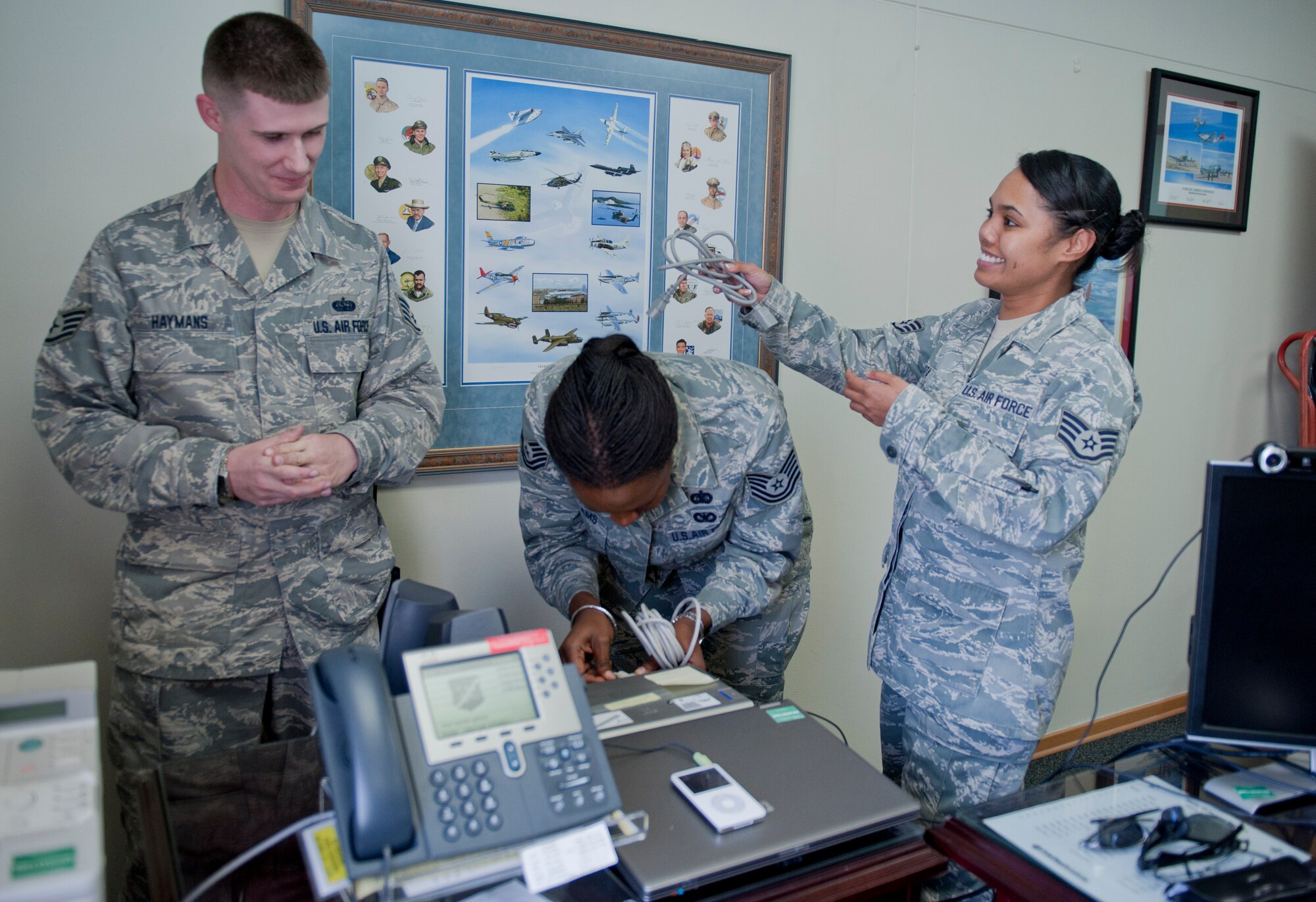 Staff Sgt. Chris Haymans, 39th Communications Squadron client systems technician, left, discusses a printer issue with Tech. Sgt. Lakiesha Williams, center, and Staff Sgt. Vanessa Kyota, both 39th Mission Support Group knowledge operations management technicians, Oct. 11, 2011, at Incirlik Air Base, Turkey. KOMT members are the liaisons between the Client Systems Team and the 39th MSG staff members for creating and ensuring completion of communications related trouble tickets. (U.S. Air Force photo by Senior Airman Anthony Sanchelli/Released) 
