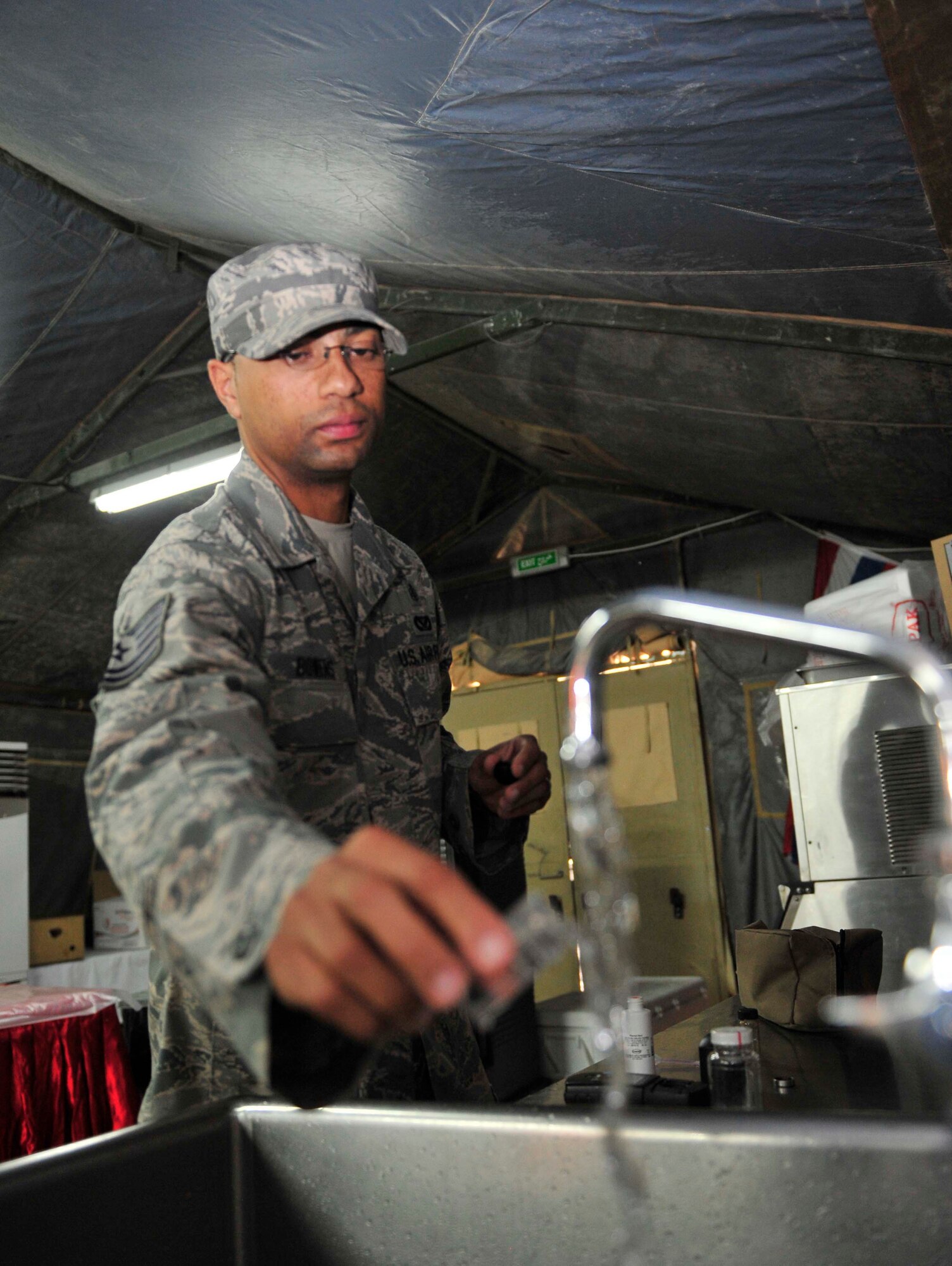 Tech. Sgt. Chris Bowens, the bioenvironmental engineering NCO in charge for the 380th Expeditionary Medical Group, tests the acidity levels of the drinking water at Windy's dining facility, Oct. 10, 2011, at the 380th Air Expeditionary Wing in Southwest Asia. Medical group officials monitor the dining facilities weekly.  Bowens is deployed to the 380th AEW from Andrews Air Force Base, Md.  (U.S. Air Force photo/Tech. Sgt. Patrick Mitchell)
