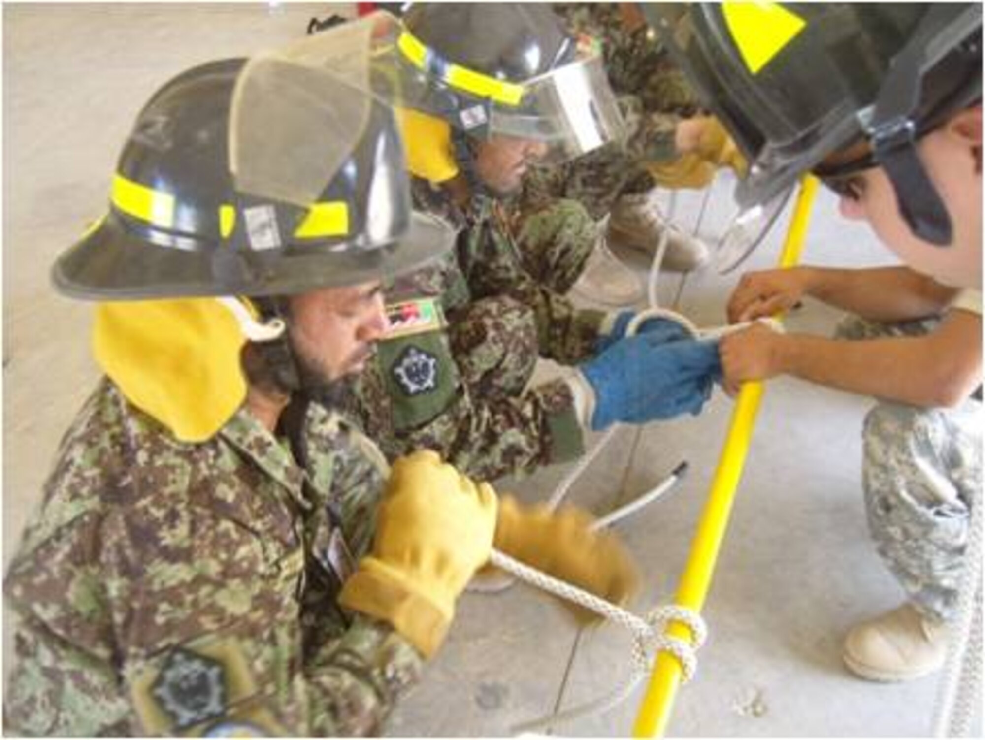 Firefighters use a training aide to secure ropes around objects while conducting level-three fire training recently. The purpose of the training explained firefighters was to add some tools to the AAF firemen toolbox that will provide and assist them in rescuing victims from second story buildings as well as help them to raise and lower equipment during fire ground operations. This training speeds up response reactions and allows for safe fire ground operations they said. (U.S. Air Force courtesy photo)
