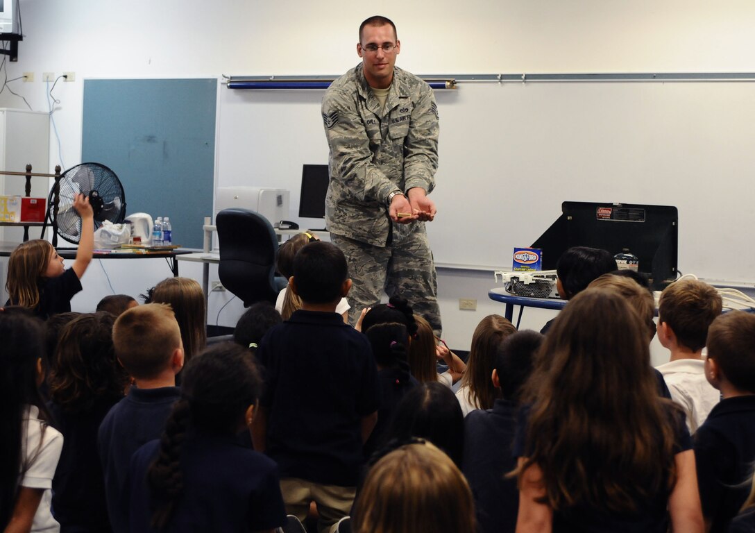 ANDERSEN AIR FORCE BASE, Guam—Staff Sgt. Andrew Ohls, 36th Civil Engineer Squadron fire department member, shows first-grade children different materials that cause fire during a visit to Andersen Elementary School here, Oct. 13. Throughout Fire Prevention Week, the Andersen Fire and Emergency flight has worked hard to teach fire safety to the base community. (U.S. Air Force photo by Senior Airman Benjamin Wiseman/Released)