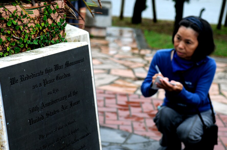 An Okinawan visiting sacred sites on Kadena Air Base, Japan, transcribes the text from a memorial Oct. 5. Okinawans are often sponsored onto the base so they can visit sites of historical, religious and ancestral significance. (U.S. Air Force photo/ Airman 1st Class Maeson L. Elleman)