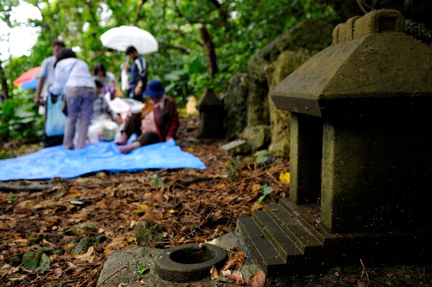 Okinawans visiting a sacred site on Kadena Air Base, Japan, enjoy a ceremonial meal at the site of Earth, Water and "Play ground" spiritual statues Oct. 5. As part of a cultural exchange, Kadena allows Okinawans to visit sacred sites on base. (U.S. Air Force photo/ Airman 1st Class Maeson L. Elleman)