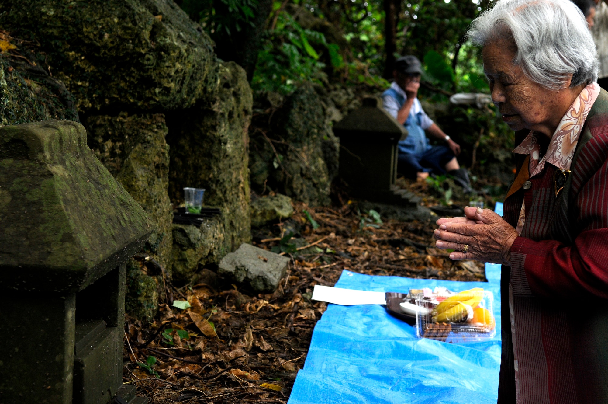 Shizuko Yara, an Okinawan visiting sacred sites on Kadena Air Base, Japan, prays to the spirits at a site Oct. 5. Okinawans are often sponsored onto the base so they can visit sites of historical, religious and ancestral significance. (U.S. Air Force photo/ Airman 1st Class Maeson L. Elleman)