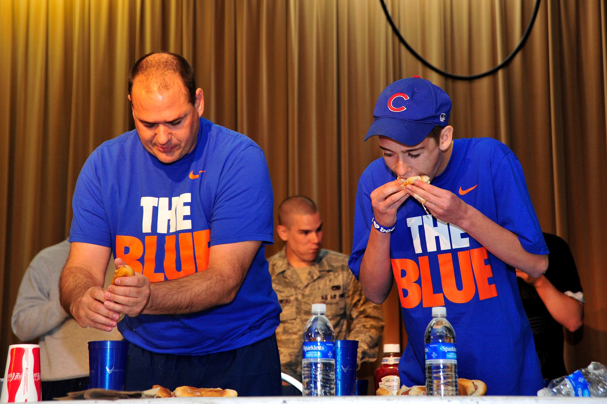 MISAWA AIR BASE, Japan -- Perrin Smith, left, 35th Maintenance Squadron, and his son, Justice Smith chow down during the hotdog eating contest on sports day here Oct. 7. The 35th Fighter Wing held a sports day to promote physical fitness, teamwork, sportsmanship and esprit de corps. The day was kicked off with a 3-mile run followed by various sporting events to include relay races, basketball, softball, ultimate frisbee, soccer and a readiness competition. Approximately 14 units from the base formed teams to participate in each event. (U.S. Air Force photo by Staff Sgt. Nathan Lipscomb)