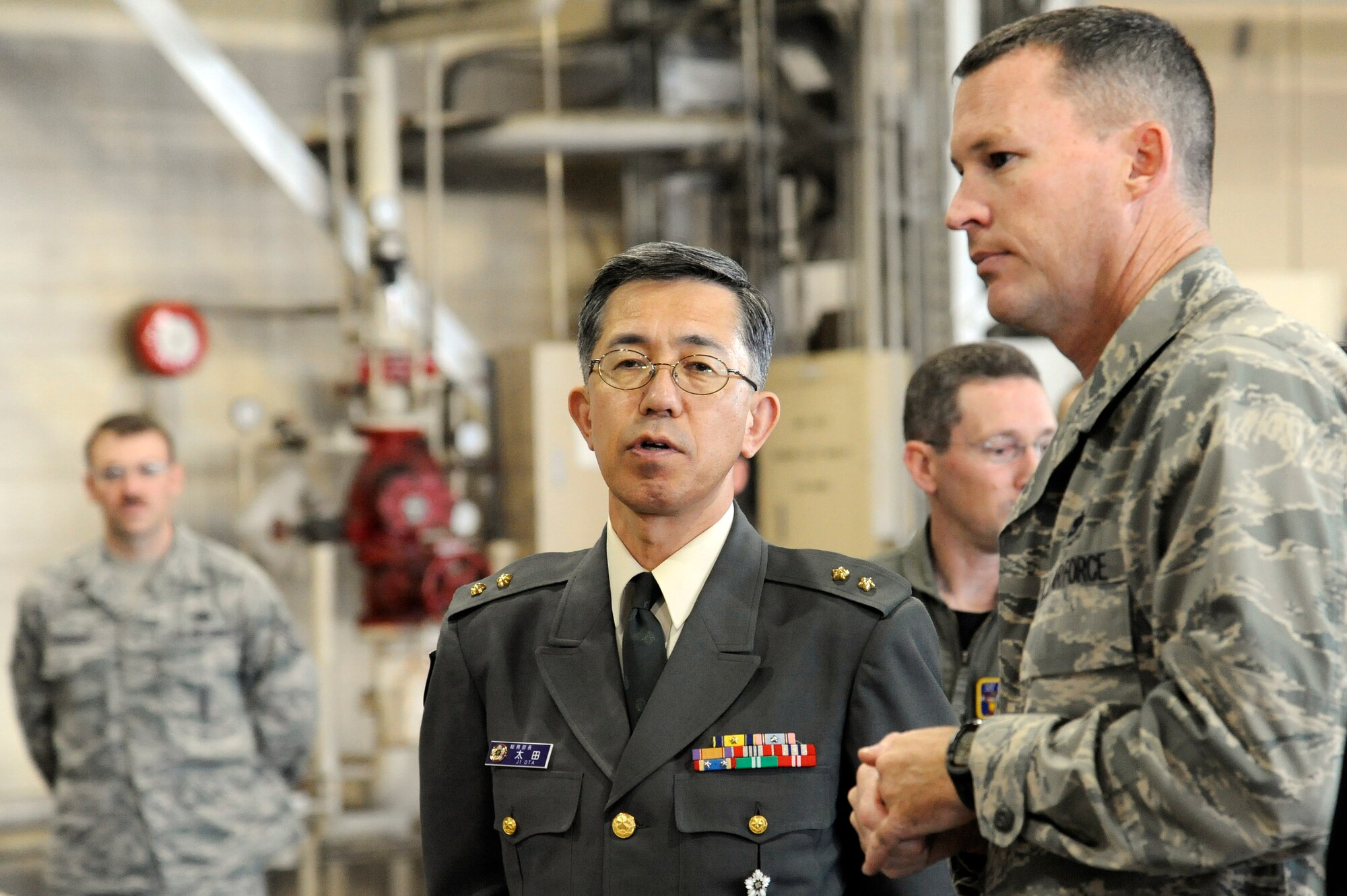 MISAWA AIR BASE, Japan - Maj. Gen. Makiya Ota, left, Director Japan Joint Staff, receives a briefing from U.S. Air Force Maj. Corey Jewell, 35th Maintenance Operations Squadron commander, during his visit here Oct. 11.  General Ota traveled to Misawa Air Base to tour base facilities and visit with the Japan Air Self-Defense Force. (U.S. Air Force photo/Tech. Sgt. Marie Brown)