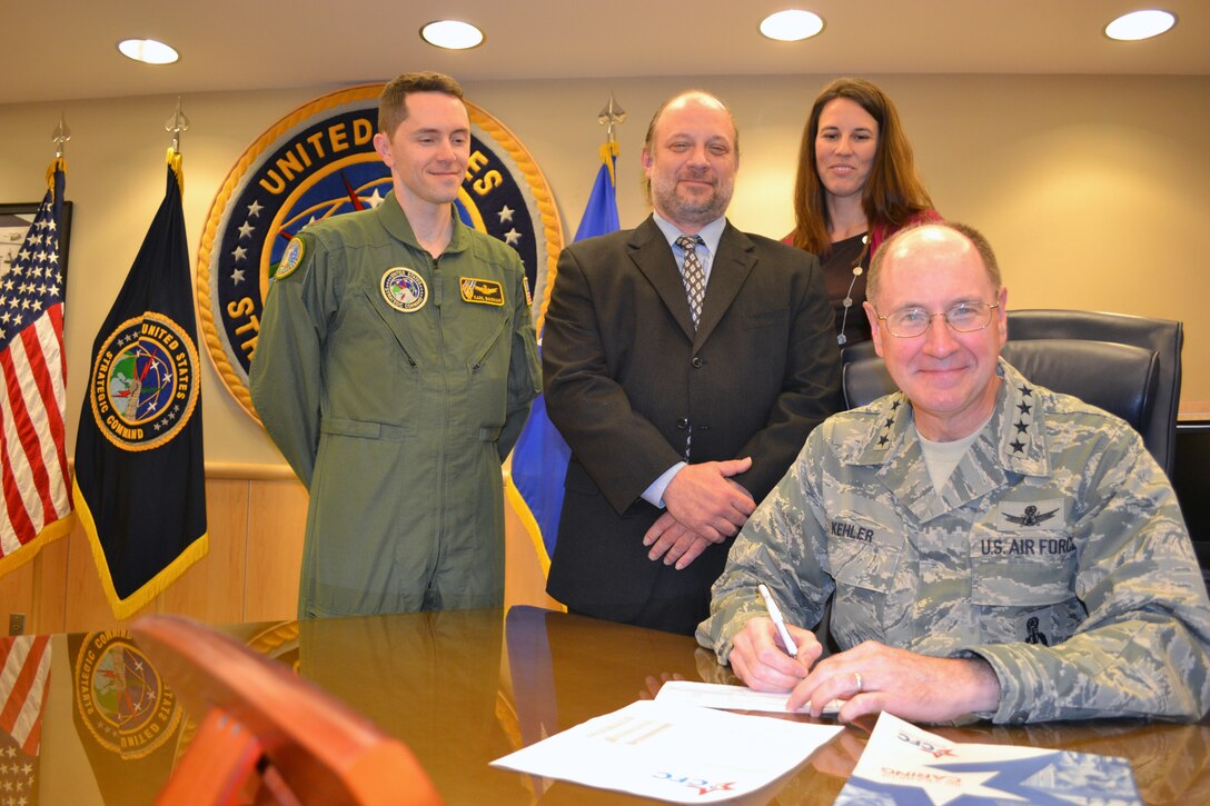 Gen. Robert Kehler, commander of U. S. Strategic Command, signs his 2011 Combined Federal Campaign pledge form while CFC coordinators U.S. Air Force Maj. Karl Basham, Mark Drabik and Marianne Nassef (from left to right) stand by. <br><br>CFC is the world's largest and most successful annual workplace charity, with more than 300 CFC campaigns conducted throughout the country and internationally to help raise millions of dollars each year. Pledges made by Federal civilian, postal and military donors during the campaign season support eligible non-profit organizations providing health and human service benefits throughout the world.