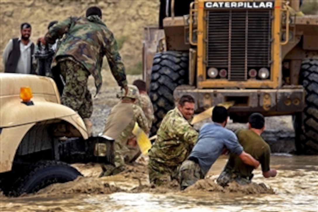 U.S. Army Staff Sgt. Jaymz Touchstone works with Afghan soldiers to recover an Afghan army vehicle stuck in the Lurah River in Afghanistan's Shinkai district, Oct. 12, 2011. Touchstone is a civil affairs soldier assigned to Provincial Reconstruction Team Zabul. Afghan soldiers asked the provincial team for help because of its abilities to recover vehicles.