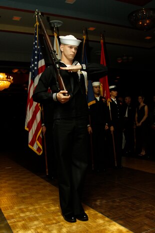 Seaman Apprentice Andrew Barr, 2011 Navy Ball color guard rifleman, performs a present arms during the marching of the colors at the 2011 Navy Ball held in the Club Iwakuni ballroom here Oct. 14. Both American and Japanese flags were marched to show respect and honor to the station’s host nation.