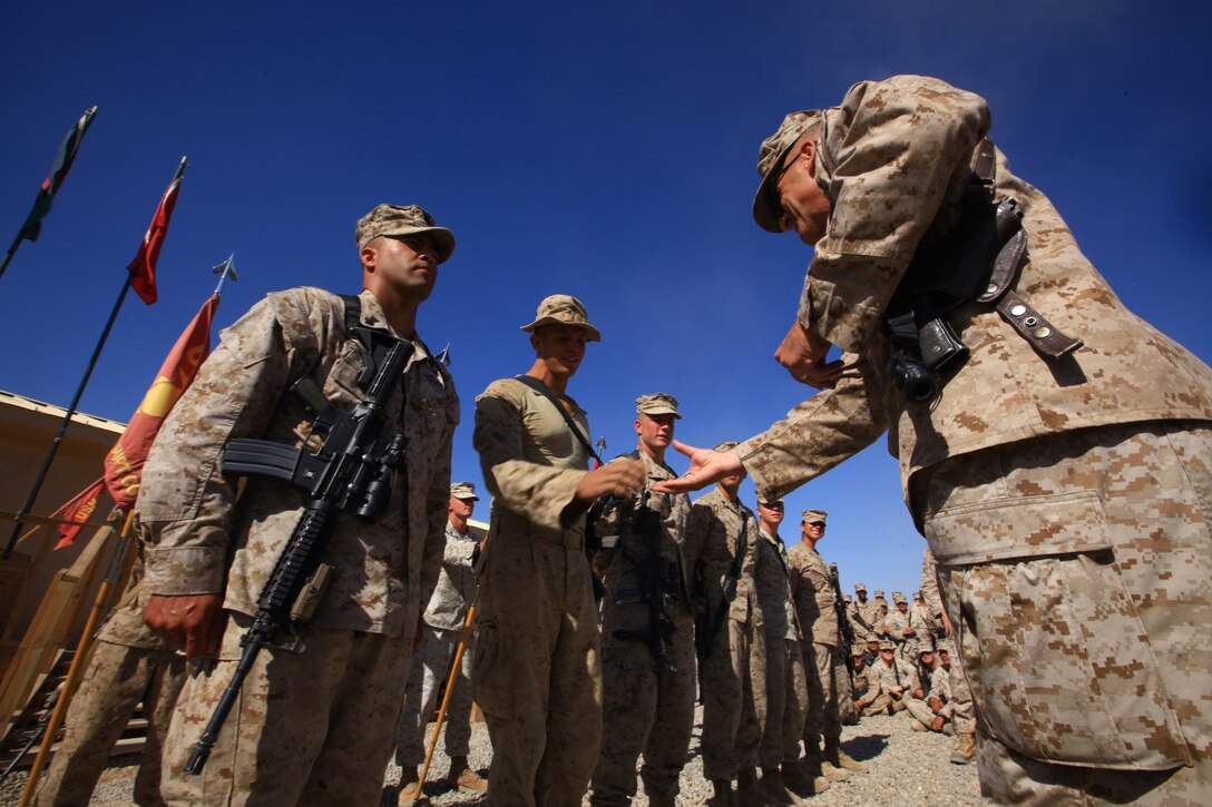 Brig. Gen. Michael G. Dana (right), commanding general of 2nd Marine Logistics Group (Forward), hands out coins to select Marines with Combat Logistics Battalion 7, during the final days of their seven-month tour aboard Camp Dwyer, Afghanistan, Oct. 14.  Combat Logistics Battalion 7 transferred authority to CLB-1 Oct. 15.  (U.S. Marine Corps photo by Cpl. Katherine M. Solano)