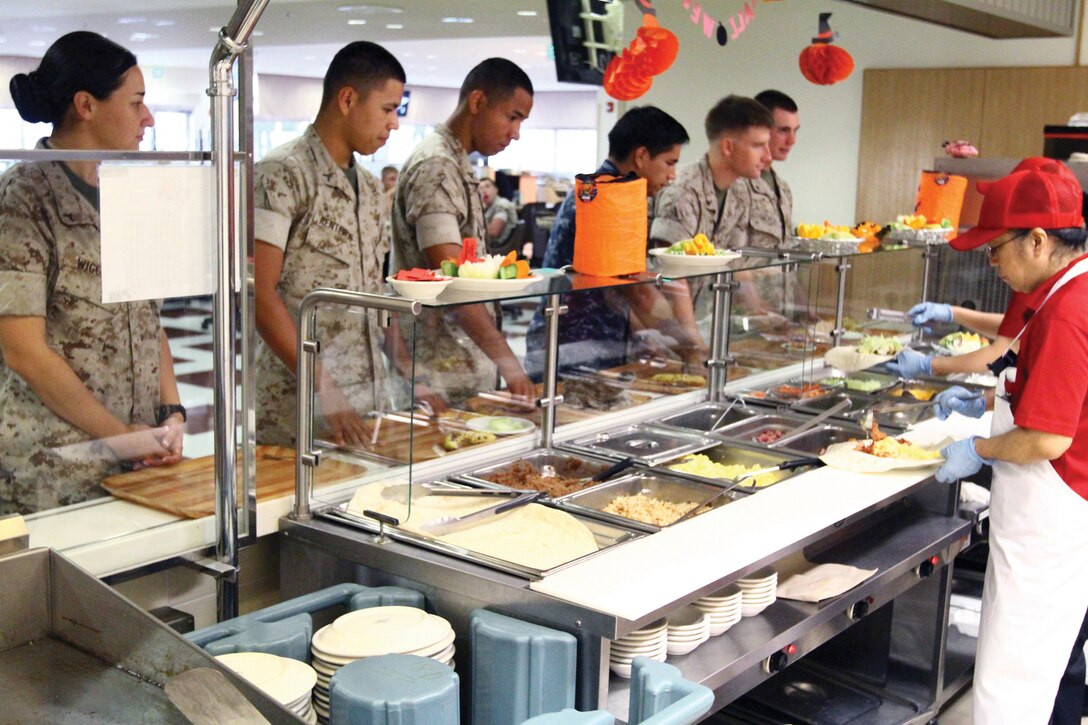 Marines and sailors stationed on Camp Foster await their self-created Oki-burrito at the Foster Mess Hall Oct. 14. The new Oki-burrito is part of a new island-wide campaign to encourage Marines and sailors to stop paying out of pocket to eat elsewhere by introducing more appetizing and convenient food options at the mess halls.