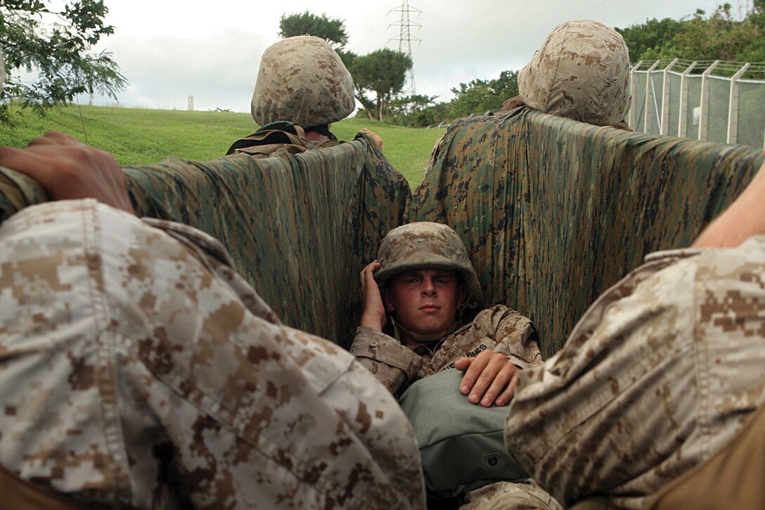 Lance Cpl. Justin Hancock, an aviation systems radio technician with MASS-2, is carried away on a stretcher during the final challenge of a small-unit leadership exercise at the Habu Trail on MCAS Futenma Oct. 14. The timed-event encouraged small-unit leaders and their Marines to persevere through a mentally and physically challenging six-mile course.