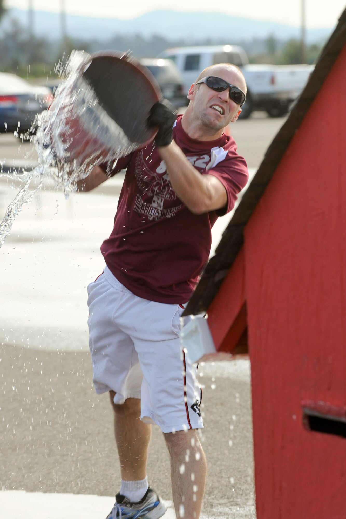 VANDENBERG AIR FORCE BASE, Calif. – 2nd Lt. Brandon Jacobson, 30th Comptroller Squadron financial services flight commander, throws a bucket of water on a roof during the bucket brigade portion of the Fire Muster competition at the parade grounds here Friday, Oct. 14, 2011. The Fire Muster competition is held during Vandenberg’s Fire Prevention week celebrations to help demonstrate the physical and mental struggles that firefighters go through. (U.S. Air Force/Staff Sgt. Levi Riendeau)