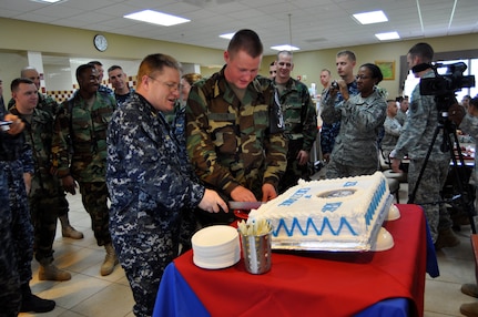 Senior Chief Petty Officer Edwin Carr, the oldest sailor assigned to Joint Task Force-Bravo, cuts the cake with the youngest sailor, Master at Arms Seaman Dustin Tyler, celebrating the Navy’s Birthday in the dining facility Oct. 13, 2011, at Soto Cano Air Base, Honduras.  JTF-Bravo sailors honored the Navy’s 236th birthday with the traditional cutting of the cake. (U.S. Air Force photo/Martin Chahin)