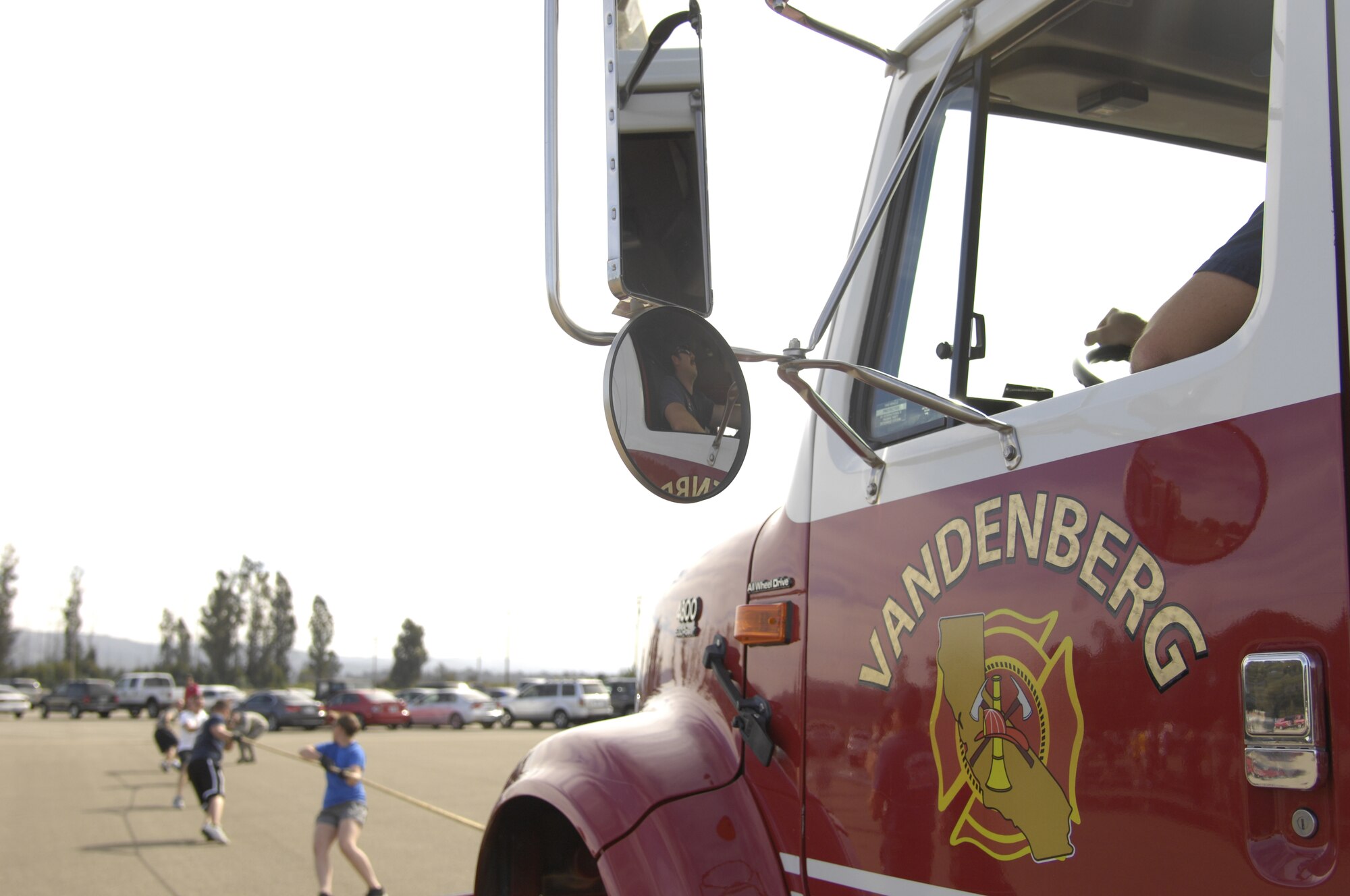 VANDENBERG AIR FORCE B ASE, Calif. –  The 30th Space Communication Squadron team pulls the fire engine as Alan Johnson, a 30th Civil Engineer Squadron fire engineer, steers the engine during the fire engine pull at this year’s Fire Muster competition at the parade grounds here Friday, Oct. 14, 2011. The Fire Muster competition is just one of the many events held this week in support of National Fire Prevention Week. (U.S. Air Force photo/Senior Airman Lael Huss)