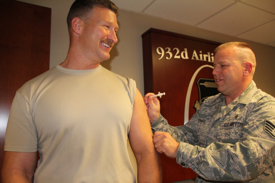 Chief Master Sgt. James Hutto is pleased to receive his annual flu vaccination courtesy of Staff Sgt. Jesse Thomas, 932nd Aerospace Medicine Squadron. Thomas and other medical personnel visited units and the commander's call to ensure reservists recieved the flu shot.  (U.S. Air Force photo/Tech. Sgt. Christoper Parr)  