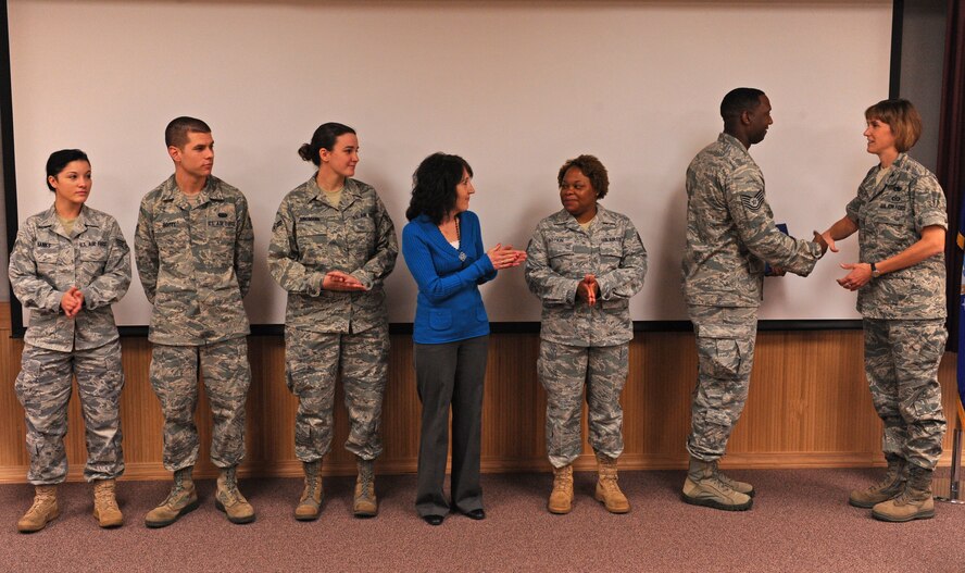Col. Kristina O’Brien, 7th Mission Support Group commander, presents members from the 7th Communications Squadron with the September MSG superior performer award, Oct. 13, 2011, at Dyess Air Force Base, Texas. Every month each group selects a person or team who has shown superior performance to be recognized in front of wing leadership. (U.S. Air Force photo by Airman 1st Class Peter Thompson/Released)