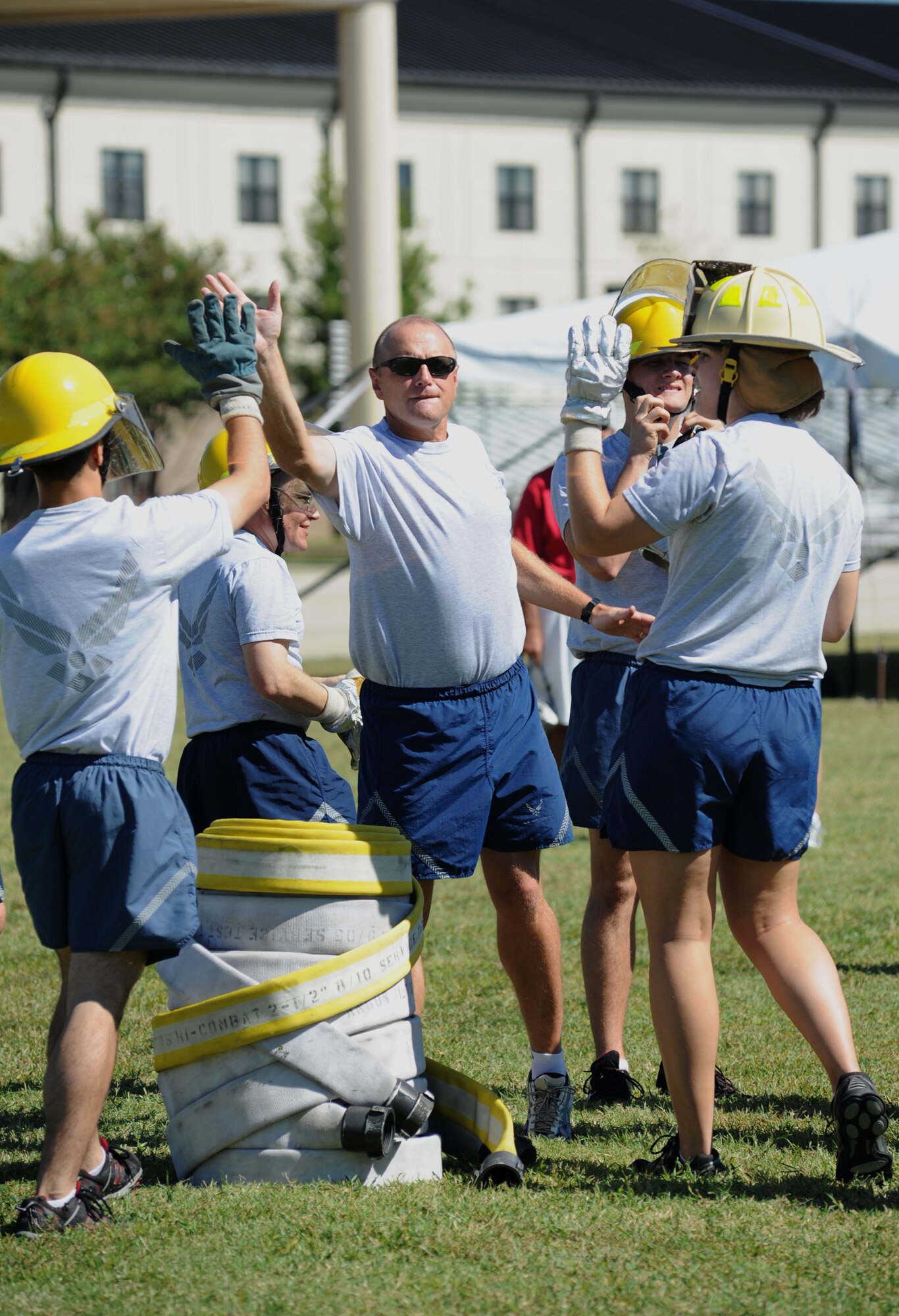 Brig. Gen. Andrew Mueller, 81st Training Wing commander, center, high fives his teammates after completing the "Firefighter Challenge" at the Fire Muster, Oct. 14, 2011, Keesler Air Force Base, Miss.  The Fire Muster is an event sponsored by the Keesler Fire Department in conjunction with Fire Prevention Week Oct. 11-15.  (U.S. Air Force photo by Kemberly Groue)