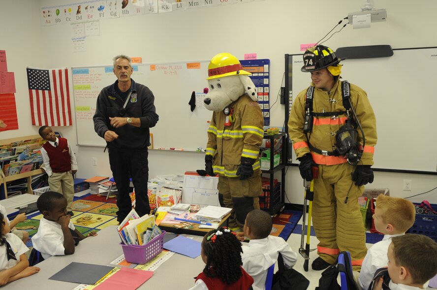 Lt. Jay Thomas, Senior Airman Garett Robledo and Sparky, the fire prevention dog, educate children from the Imagine Andrews Public Charter School, Joint Base Andrews, Md., Oct. 14 during an annual visit that teaches students the basics of fire safety. Children were free to ask questions and interact with Sparky. (U.S. Air Force photo by Tech. Sgt. Raymond Mills)