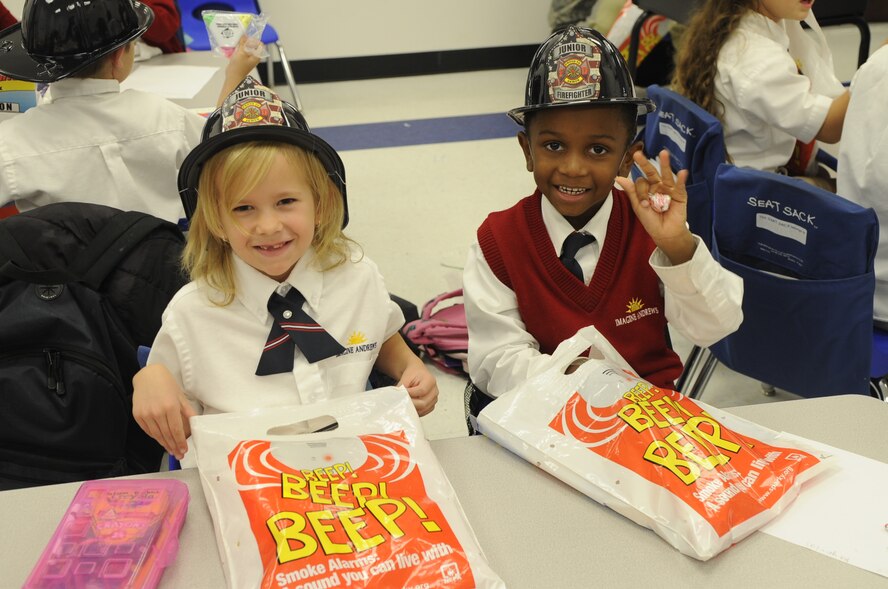 Autumn Bierbach and Jermarco Reynolds received fire hats Oct. 14 during an annual visit from the 11th Wing fire department on Joibt Base Andrews, Md. During the visit children learned fire safety principals and interacted with Sparky, the fire prevention dog. (U.S. Air Force photo by Tech. Sgt. Raymond Mills)