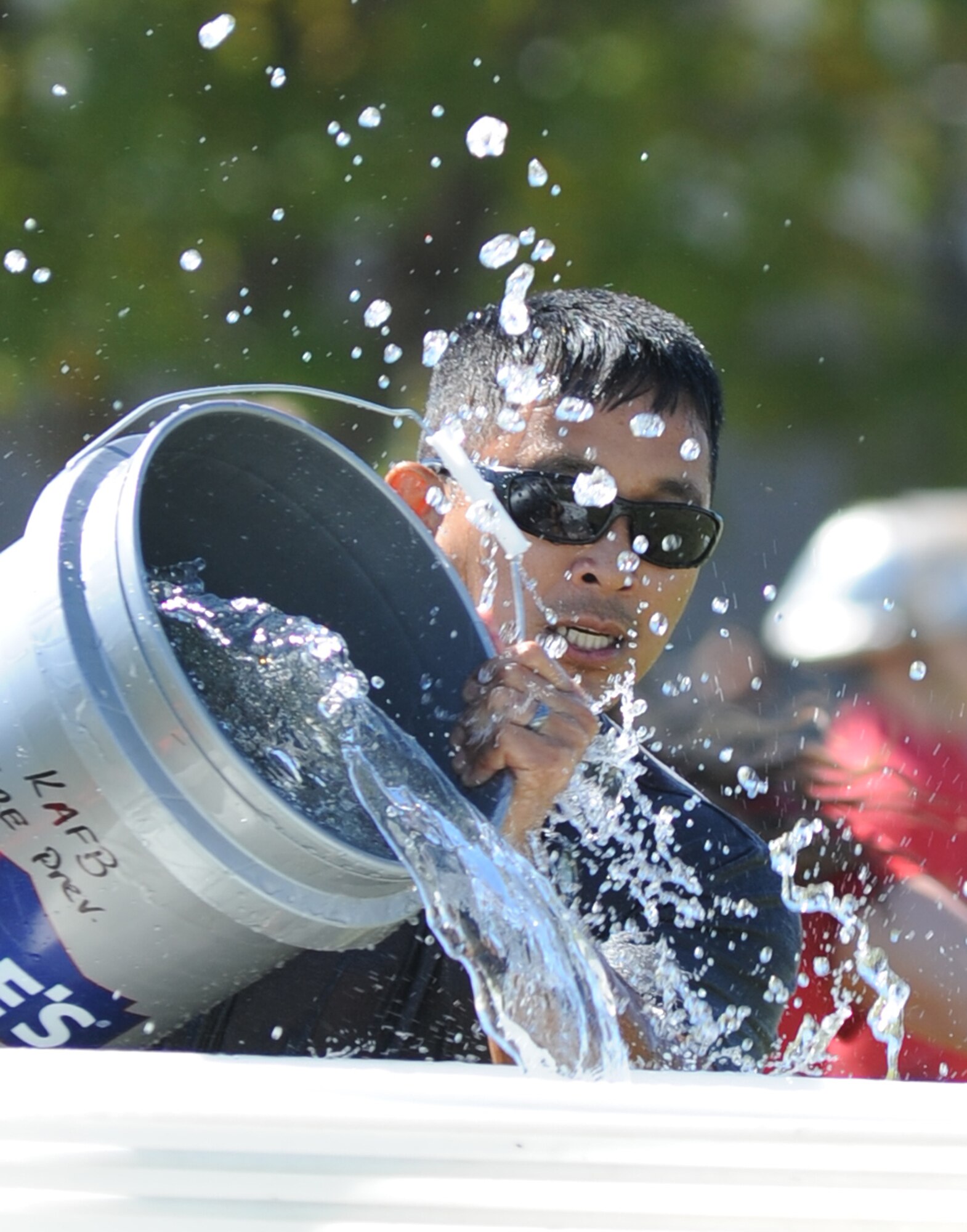 Master Sgt. Jerry Dameron, 81st Medical Operations Squadron, dumps a bucket of water into a barrel during the "Bucket Brigade" competition at the Fire Muster, Oct. 14, 2011, Keesler Air Force Base, Miss. The Fire Muster is an event sponsored by the Keesler Fire Department in conjunction with Fire Prevention Week Oct. 11-15.  (U.S. Air Force photo by Kemberly Groue)