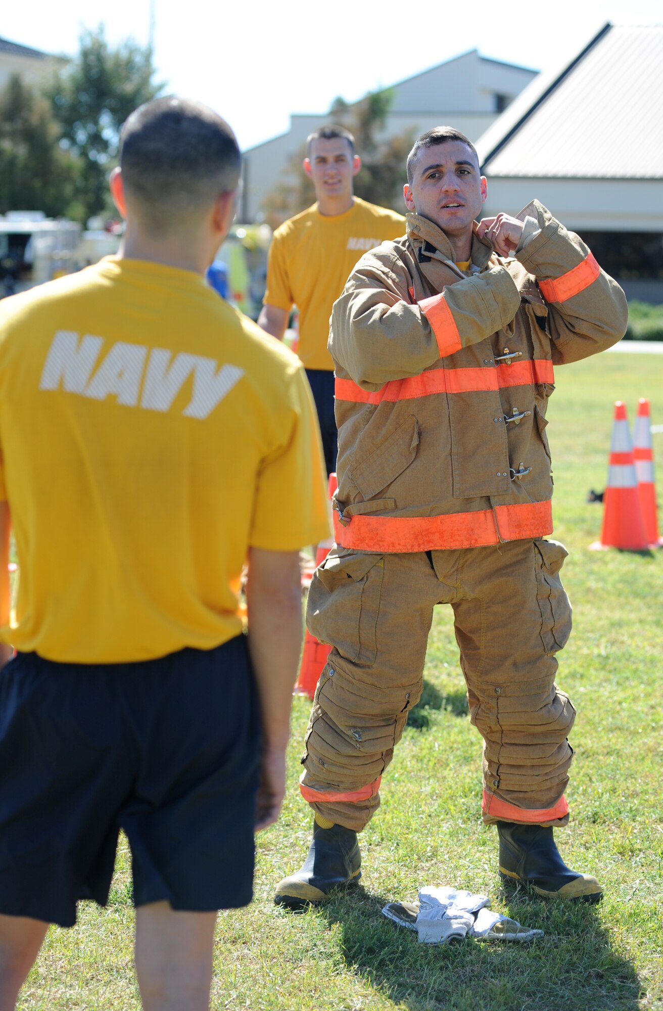 Petty Officer 2nd Class Raymond Lee, Center for Naval Aviation Technical Training Unit, waits his turn as his teammate Chief Petty Officer Richard Rendon, CNATTU, dresses in bunker equipment during the Bunker Drill competition at the Fire Muster, Keesler Air Force Base, Miss., Oct. 14, 2011. The Fire Muster is an event sponsored by the Keesler Fire Department in conjunction with Fire Prevention Week Oct. 11-15.  (U.S. Air Force photo by Kemberly Groue)