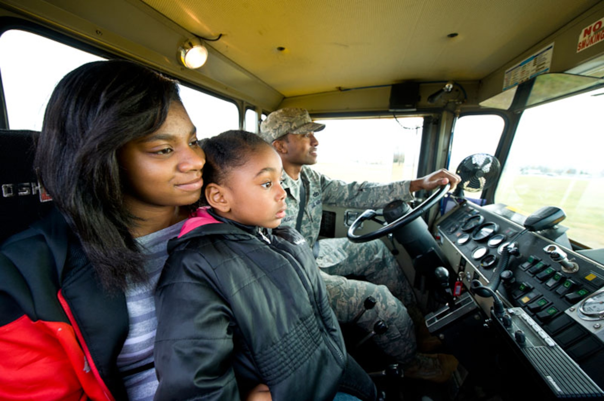 JOINT BASE ELMENDORF-RICHARDSON, Alaska -- The 773rd CES's equipment was preparing for its annual parade to display the equipment used to remove snow on base. Staff Sergeant Brian Hughes of the 773rd Civil Engineer Squadron takes his two daughters, Ka' Lisia, 16, and Jasmyn, 4, on a ride in his rollover plow during the parade on JBER, Oct. 7.  (U.S. Air Force photo/Johnathon Green)