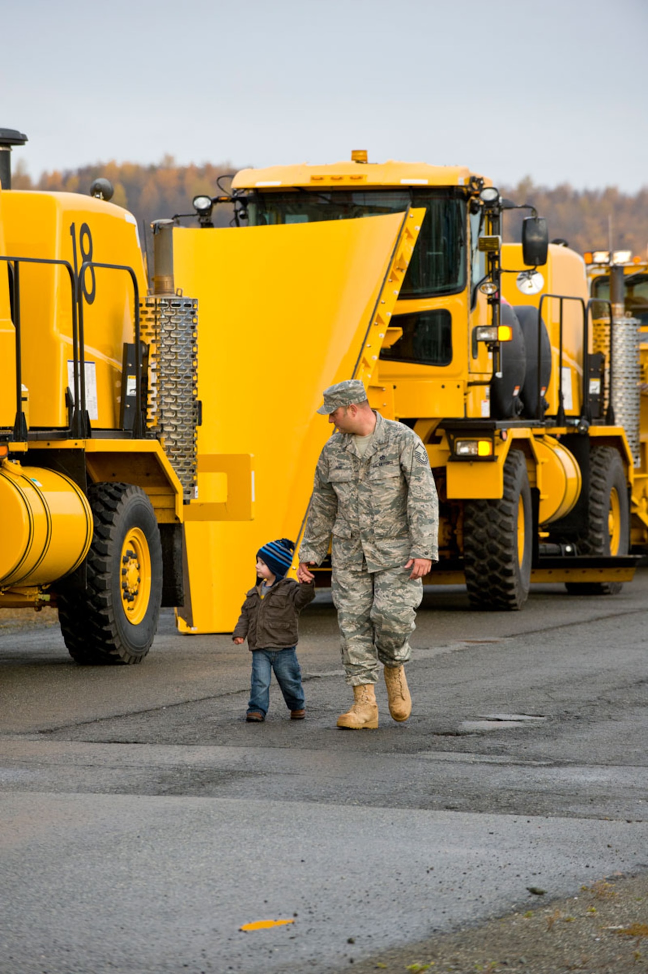 JOINT BASE ELMENDORF-RICHARDSON, Alaska -- Master Sergeant Andrew Bone of the 773rd Civil Engineer Squadron shows his two year old son, Ben, some of the snow removal equipment he is in charge of, Oct. 7. The 773rd CES's equipment was preparing for its annual parade to display the equipment used to remove snow on base. (U.S. Air Force photo/Johnathon Green)