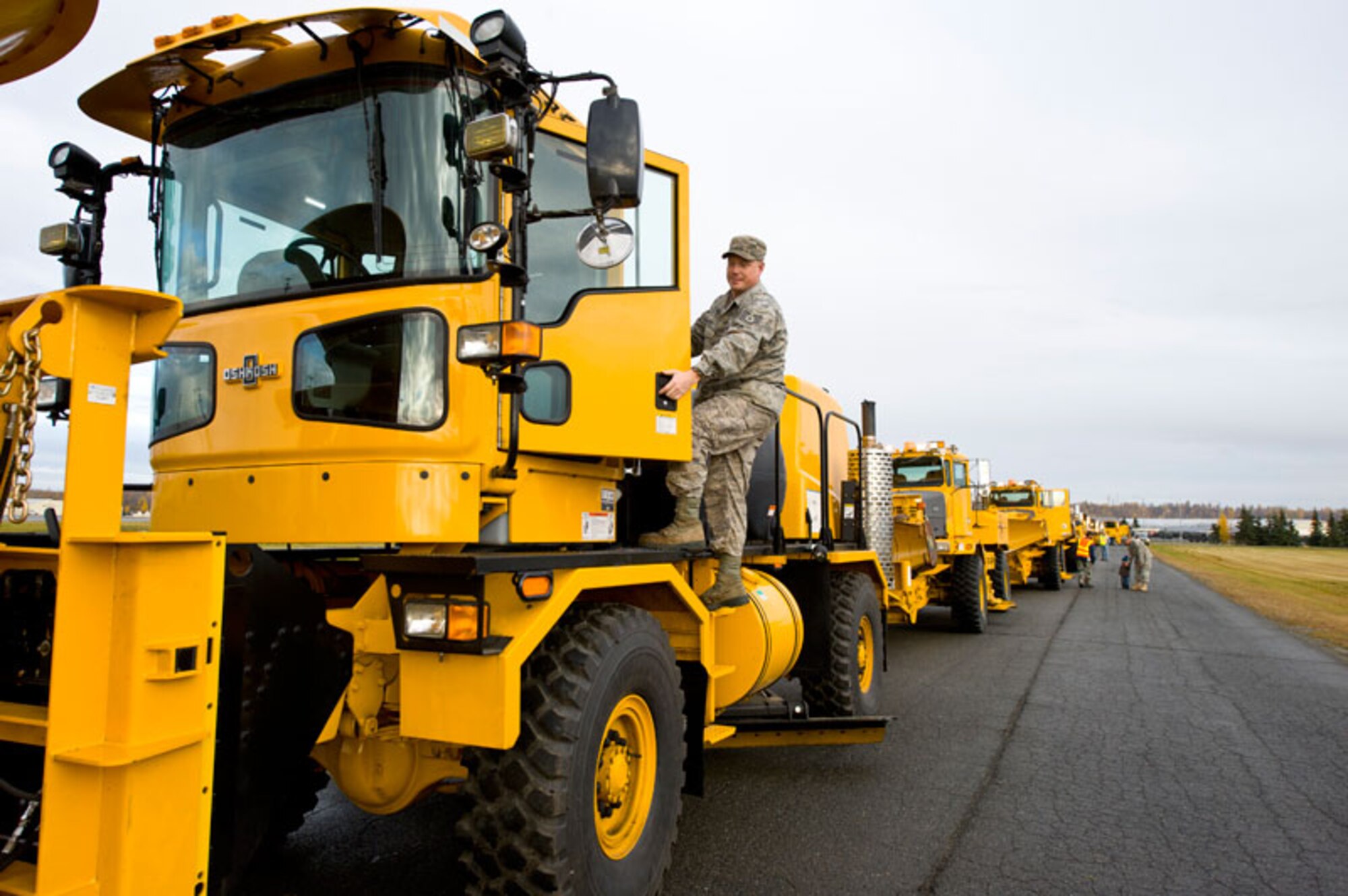 JOINT BASE ELMENDORF-RICHARDSON, Alaska -- Staff Sergeant Franklin Hacecky of the 773rd Civil Engineer Squadron climbs aboard his rollover plow to drive it in the parade, Oct. 7. The 773rd CES's equipment was preparing for its annual parade to display the equipment used to remove snow on base. (U.S. Air Force photo/Johnathon Green)