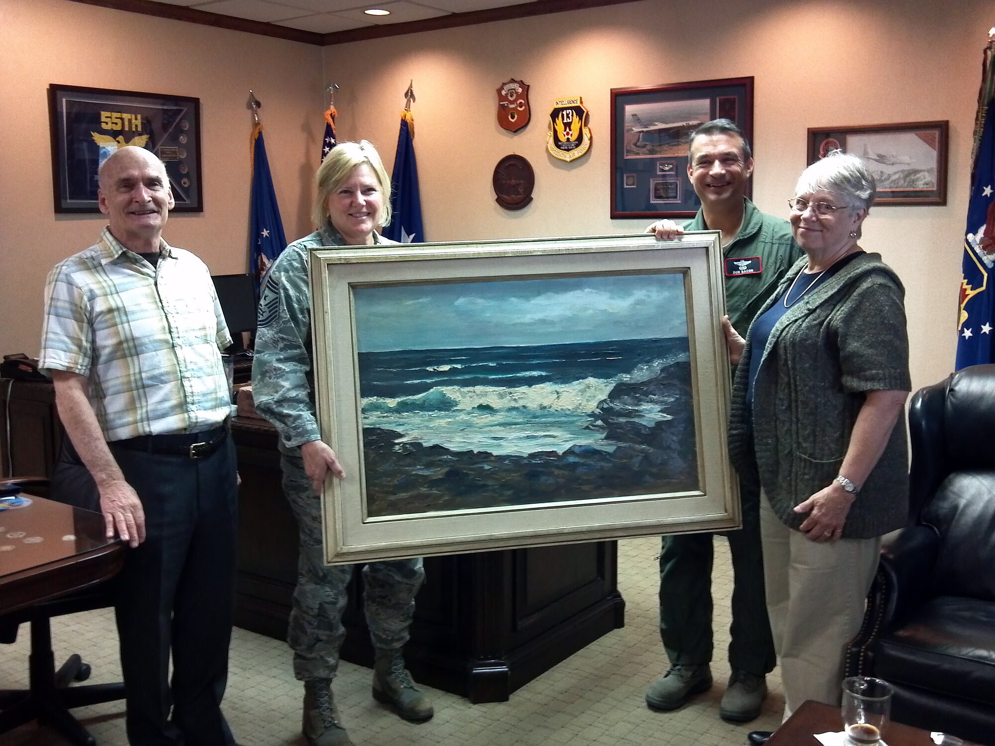 Pete Vidito and his wife Judy present Brig. Gen. Donald Bacon, 55th Wing commander, and Chief Master Sgt. Suzan Sangster, 55th Wing command chief, with a Helen LeMay painting in the 55th Wing headquarters building on Offutt Air Force Base, Neb., Oct. 6. Helen LeMay was the wife of Gen. Curtis E. LeMay, former chief of staff of the Air Force and namesake for the Gen. Curtis E. LeMay Foundation that helps widows of retired military personnel. (U.S. Air Force photo by Capt. Gregory M. Guevara/Released)