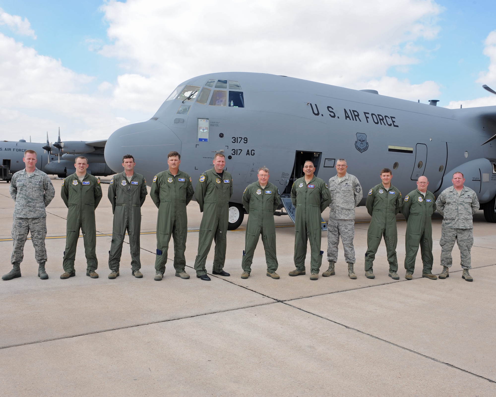The crew of the new C-130 J-model gathers outside the aircraft, Oct. 12, 2011, at Dyess Air Force Base, Texas. The aircraft is the ninth of 28 to be delivered to Dyess by 2013, replacing the current aging fleet of C-130 H models. (U.S. Air Force photo by Airman 1st Class Peter Thompson/Released)