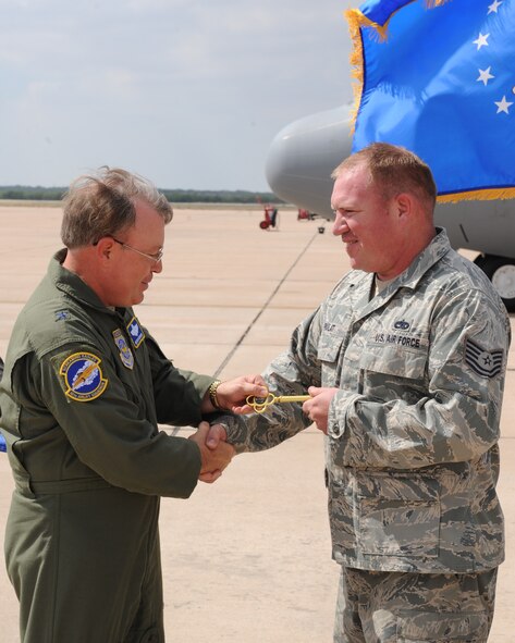 Brig. Gen. Bryan Benson, 18th Air Force vice commander, presents Tech. Sgt. Howard Pavlat, 317th Aircraft Maintenance Squadron, the honorary key at the C-130 J-model number nine arrival, Oct. 12 2011, at Dyess Air Force Base, Texas. The aircraft is the ninth of 28 to be delivered to Dyess by 2013, replacing the current aging fleet of C-130 H models. (U.S. Air Force photo by Airman 1st Class Peter Thompson/Released)