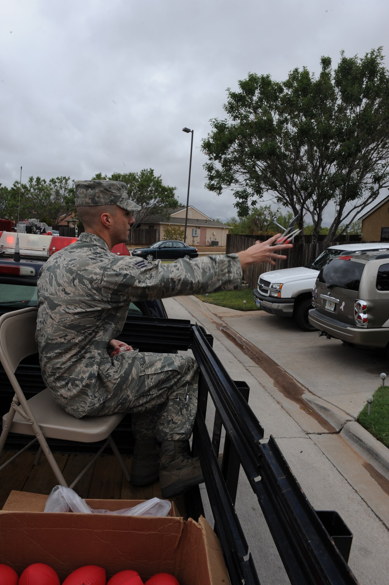 Senior Airman Adam Preston, 7th Civil Engineer Squadron, throws treats to children and families during the parade to kick-off Fire Prevention Week, Oct. 09, 2011, at Dyess Air Force Base, Texas.  Fire Prevention Week is geared towards placing emphasis on fire and safety and is structured to reach the maximum amount of people in the Dyess community.  (U.S. Air Force photo by Airman 1st Class Peter Thompson/Released)