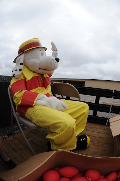 Sparky the fire dog waves and throws treats to children and families during the parade  to kick-off Fire Prevention Week, Oct. 09, 2011, at Dyess Air Force Base, Texas.  Fire Prevention Week is geared towards placing emphasis on fire and safety and is structured to reach the maximum amount of people and all demographics of the Dyess community.  (U.S. Air Force photo by Airman 1st Class Peter Thompson/Released)