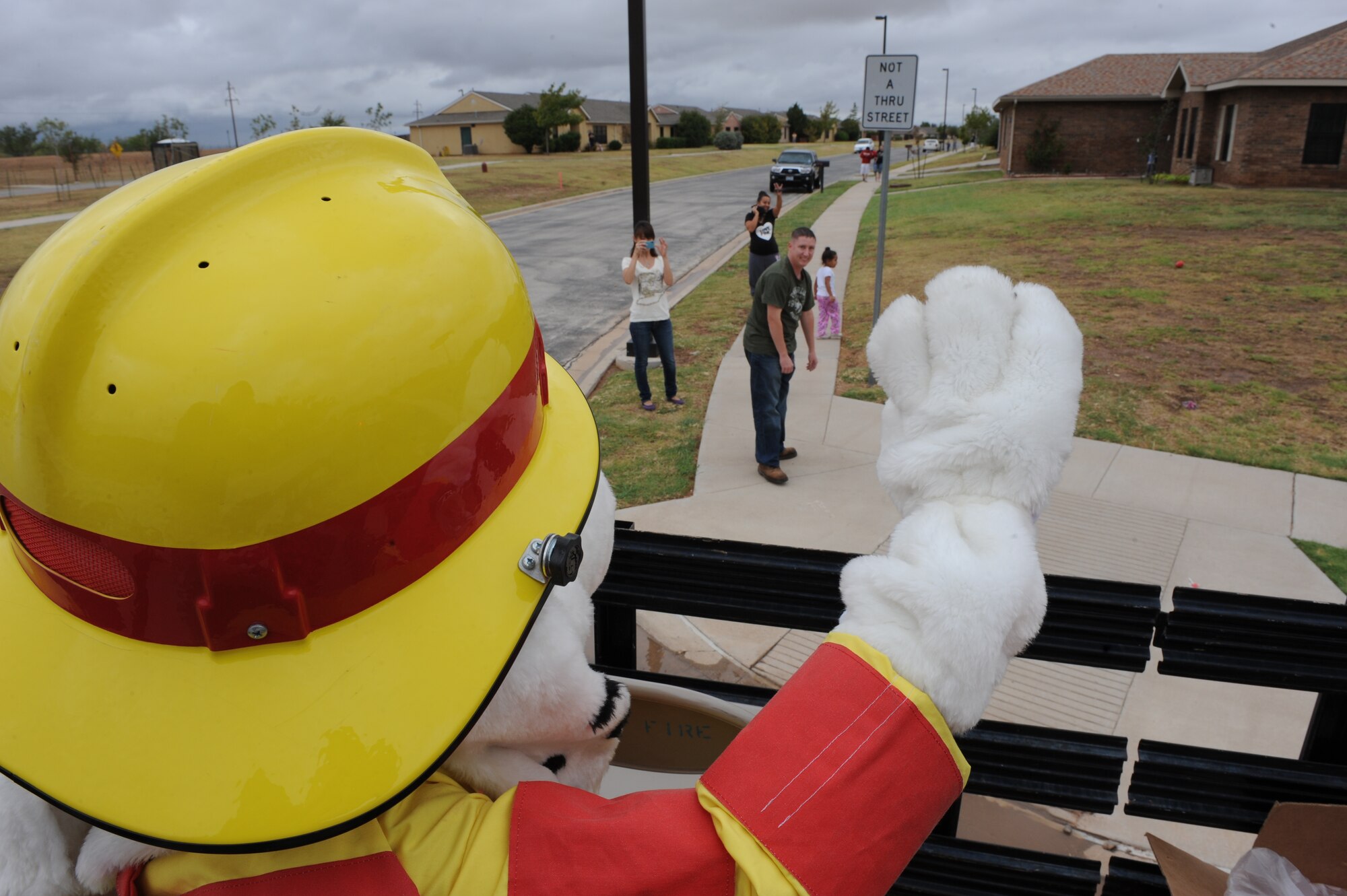 Sparky the fire dog waves to children and families during the parade to kick off Fire Prevention Week, Oct. 09, 2011, at Dyess Air Force Base, Texas.  Fire Prevention Week is geared towards placing emphasis on fire and safety and is structured to reach the maximum amount of people in the Dyess community. (U.S. Air Force photo by Airman 1st Class Peter Thompson/Released)