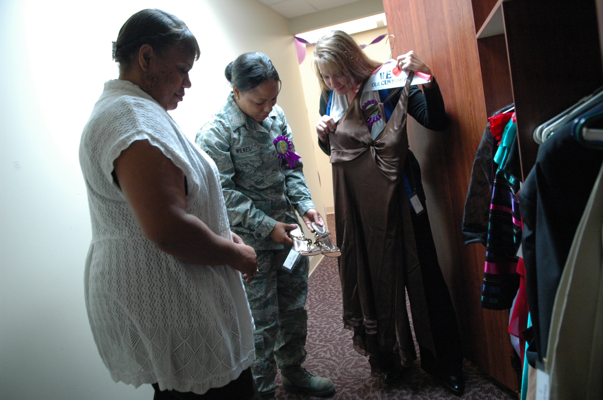 From Left: Lori Johnson Vegas, wife of 72nd Air Base Wing Command Chief Master Sgt. Kevin Vegas; Michelle Wilkes, a volunteer from the 72nd Medical Group; and volunteer Michelle Saunders, wife of ALS commandant Master Sgt. Stuart Saunders; break out some wardrobe combinations from the clothing available at Tinker Bell’s Wardrobe inside the Airman and Family Readiness Center in Bldg. 6001. (Air Force photo by Micah Garbarino)