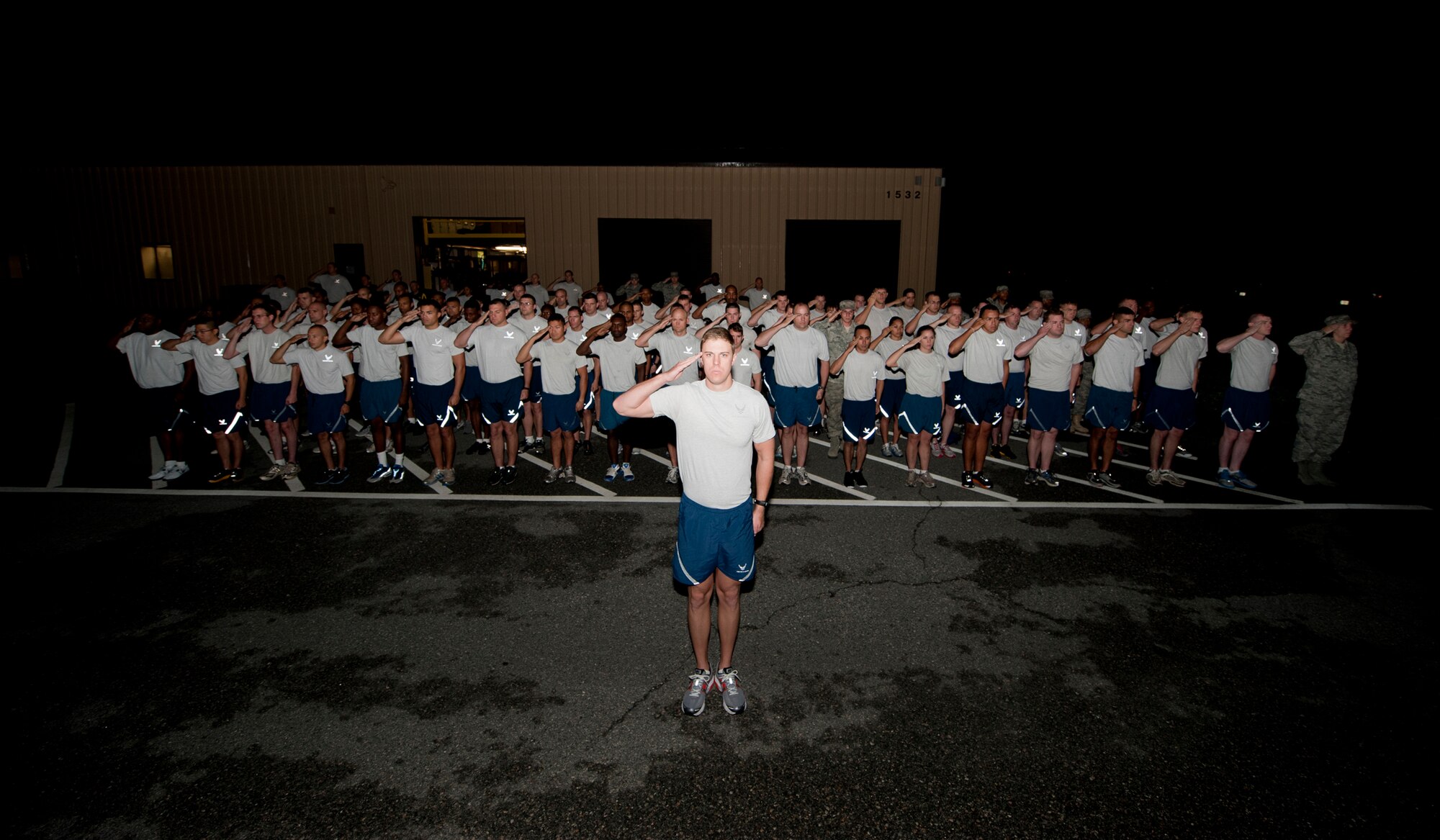 Members of the 820th Base Defense Group salute during reveille Oct. 14, 2011, at Moody Air Force Base, Ga., before beginning the annual LeeBernard Chavis Memorial Workout. The workout honors Airman 1st Class LeeBernard Chavis, a fallen member of the 824th Base Defense Squadron, who was killed in action while deployed to Camp Victory, in Baghdad, Iraq, in 2006. (U.S. Air Force photo by Staff Sgt. Jamal D. Sutter/Released)