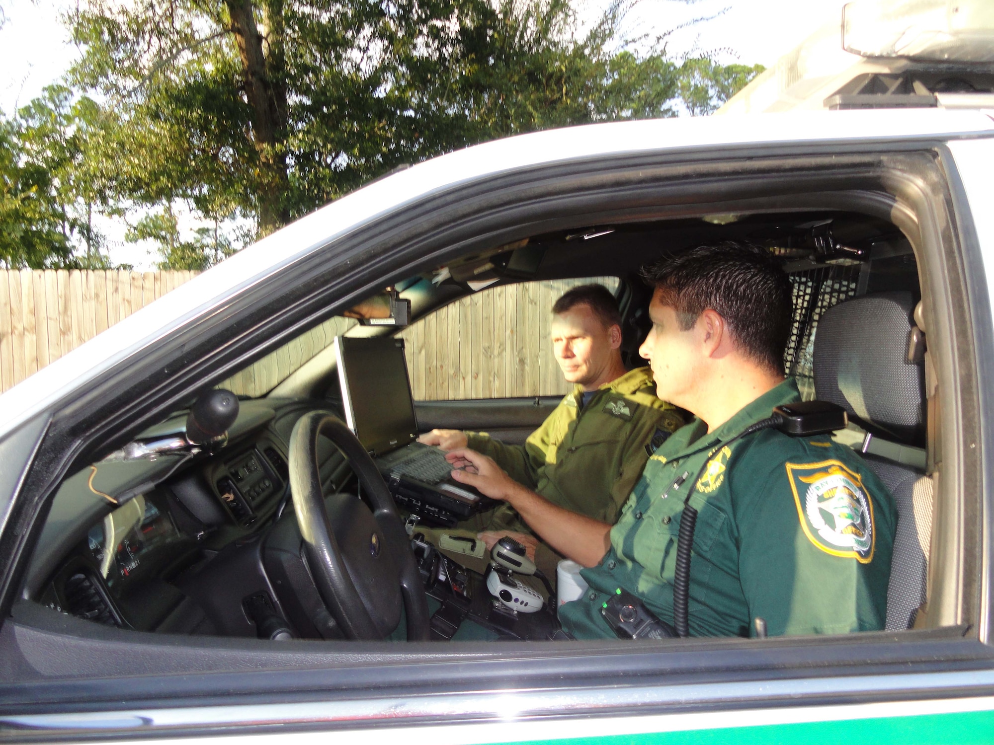 Lt. Kevin Francis, Bay County Sheriff’s Office Deputy, explains some points about the mobile data terminal to BGen. Christopher Coates, Continental U.S. North American Aerospace Defense Region deputy commander.  The terminals provide deputies critical information they need during their patrols. (Air Force Photo by Mary McHale)