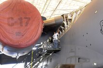 Aircraft sheet metal workers inspect and fix the affected parts on a high-corrosion area of a C-17.  U. S. Air Force file photo by Sue Sapp