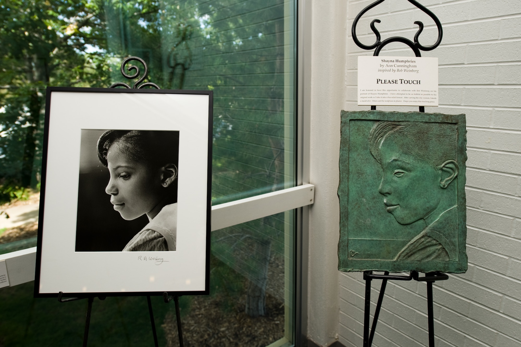 DENVER, Colo. -- A portrait of Shayna Humphries, by Robert Weinberg, sits to the left of a sculpture, by Ann Cunningham, Sept. 20, 2011.  Cunningham created this piece as a tribute to Weinberg and his increasing blindness. This sculpture is designed to be touched and allow the visually imparted to enjoy the portrait originally taken by Weinberg. (U.S. Air Force photo by Airman 1st Class Phillip Houk)