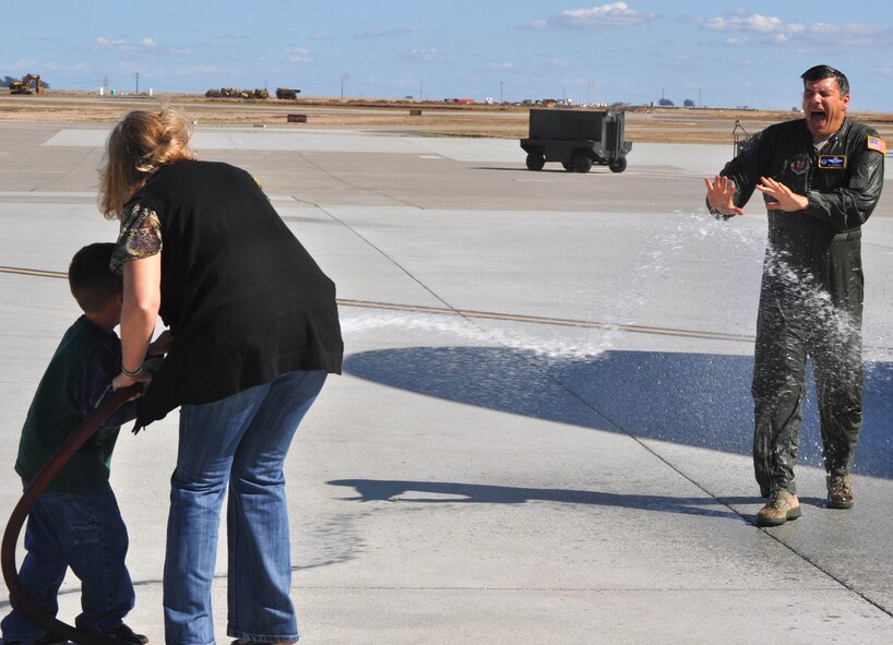 TRAVIS AIR FORCE BASE, Calif. -- 349th Operations Group Commander, Col. Al Lupenski, reacts to his cold hosing down after his "fini" flight Oct. 11, 2011.  Doing the honors are Mrs. Kathy Lupenski and Jack Flournoy, son of Col. Jay Flournoy, 349th Air Mobility Wing commander. Col. Lupenski was selected as the Wing Commander for the Reserve's 932nd Airlift Wing, Scott Air Force Base, Ill. (U.S. Air Force photo/Senior Master Sgt. Ellen L. Hatfield)